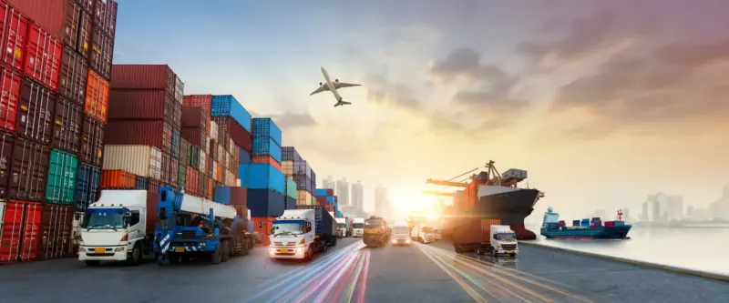 Cargo containers, freight trucks and a shipping vessel at an export port